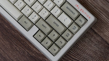 Load image into Gallery viewer, GMK MTNU Beige keycaps on white 65% keyboard, close-up of right side showing arrow cluster and navigation keys on dark wood