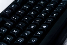 Load image into Gallery viewer, GMK MTNU WoB black keycaps extreme close-up showing sculpted MTNU profile and white legends