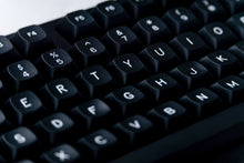 Load image into Gallery viewer, GMK MTNU WoB black keycaps on white keyboard, close-up of right side with navigation keys on dark wood