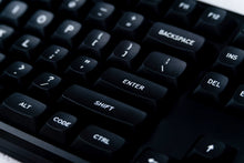 Load image into Gallery viewer, GMK MTNU WoB black keycaps on white keyboard, close-up angled view of left modifiers with plant in foreground on dark wood