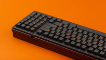 Load image into Gallery viewer, GMK CYL Carbon R3 on a black keyboard back view close up on right side angled