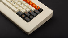 Load image into Gallery viewer, GMK CYL Carbon R3 on a cream colored keyboard close up on right side angled down