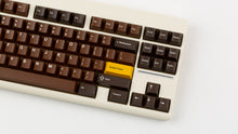 Load image into Gallery viewer, GMK CYL Chocolatier keycaps on cream NK Classic TKL keyboard, close-up of right side showing golden Golden Ticket enter key