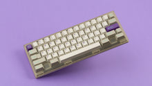 Load image into Gallery viewer, GMK CYL Hyperbeige on a frosted keyboard angled