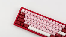 Load image into Gallery viewer, Key Kobo Darling on a red keyboard zoomed in left