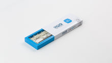 Load image into Gallery viewer, Beige QMX Stabilizers in the packaging angled