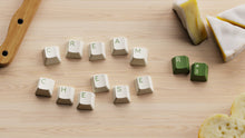 Load image into Gallery viewer, render of DCS Cream Cheese R3 banner featuring cream and yellow keycap set with red and green accents on dark background