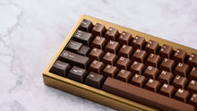 Load image into Gallery viewer, Render of GMK CYL Chocolatier keycaps on a black keyboard, full angled view showcasing the full keycap set layout