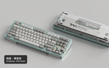 Load image into Gallery viewer, Render of Matrix Carnival keyboard in Anodized Mint Green, showing front with keycaps and back with decorative weight