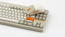 Load image into Gallery viewer, NK-M1 beige mouse resting on a beige Classic keyboard with orange accent keycaps