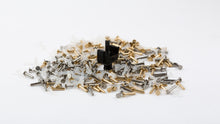 Load image into Gallery viewer, a pile of different cream+ inserts and one brass insert in the stem of a cream+ switch