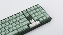Load image into Gallery viewer, Cherry Sage on a dark green keyboard zoomed in on the right