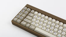 Load image into Gallery viewer, Cherry Spellbook on a brownish gold keyboard zoomed in on left