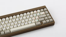 Load image into Gallery viewer, Cherry Spellbook on a brownish gold keyboard zoomed in on right